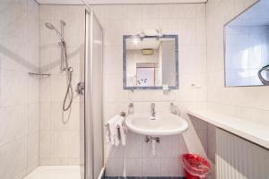 a white bathroom with a shower and a sink at Wohnung Gravensteiner Schnalserhof in Laces