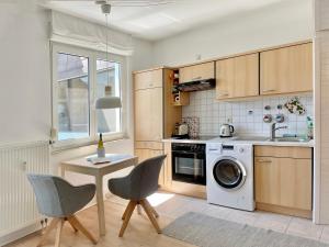 a kitchen with a washing machine and a table and chairs at Fewo Seehaase in Radolfzell am Bodensee