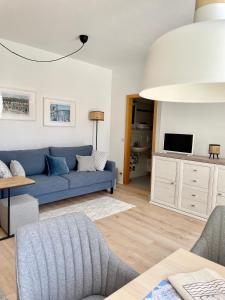 a living room with a blue couch and a tv at Fewo Seehaase in Radolfzell am Bodensee