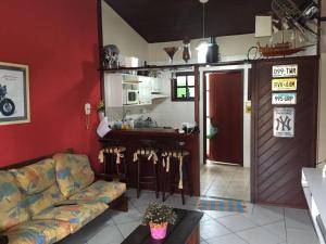 sala de estar con sofá y cocina en Praia das Dunas Residence Club, en Cabo Frío