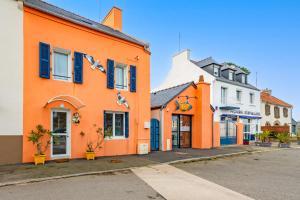 a row of orange buildings on a street at Ty Abéric maison en front de mer in Ploudalmézeau