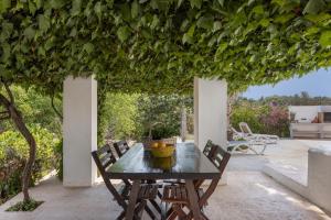 a table and chairs on a patio with a pergola at Finca Can Paci in Santa Eularia des Riu +19 photos