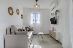 ein weißes Wohnzimmer mit Sofa und Fernseher in der Unterkunft Casa Sofia in Roche