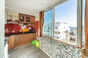 a kitchen with a large window with a view at Apartamento Belmar in Armação de Pêra