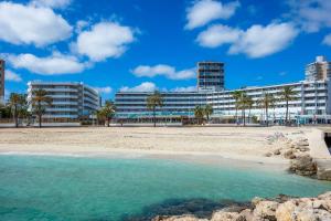 a beach in front of a large building at First Line Mediterranean Apartment in Calvià