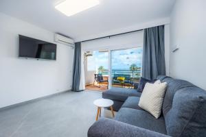a living room with a couch and a view of the ocean at First Line Mediterranean Apartment in Calvià