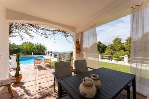 a patio with a table and chairs and a pool at Casa Rocas in Mijas