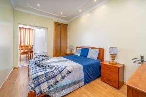 a bedroom with a bed with a blue comforter at Apartamento Belmar in Armação de Pêra