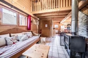 a living room with a couch and a wood stove at Chalet 6p Confort - Le Morlay in Verchaix