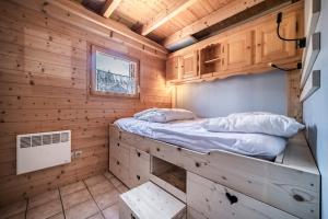 a bedroom in a log cabin with a bed at Chalet 6p Confort - Le Morlay in Verchaix