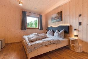 a bedroom with a bed in a room with wooden walls at Ratscheinerhof App Waldruhe in Lazfons