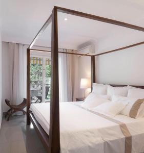 a bedroom with a canopy bed and a window at Con Encanto in Port de Soller