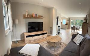 a living room with a couch and a television at Landhaus Steinrose in Bodensdorf