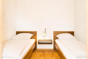 two beds in a room with a side table at Ferienwohnung Anneliese in Neukirch