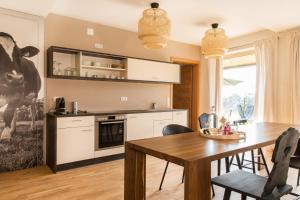 a kitchen with a table and a cow on the wall at Ferienwohnung Anneliese in Neukirch
