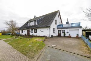 a white house with a driveway in front of it at Haus Halligblick in Dagebüll