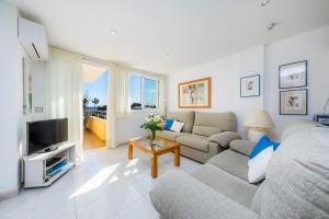 a living room with a couch and a tv at Apartment La Veleta with Sea View in El Port