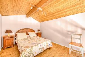 a bedroom with a bed and a wooden ceiling at Entre Vignobles Et Océan in Queyrac