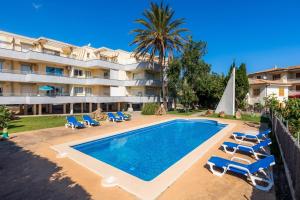 a resort with a swimming pool and chairs and a building at Apartment La Veleta with Sea View in El Port