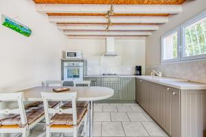 a kitchen with a table and some chairs in it at Entre Vignobles Et Océan in Queyrac +11 photos
