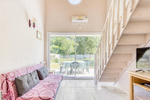 a living room with a couch and a staircase at Entre Vignobles Et Océan in Queyrac