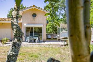 a house with a table and chairs in a yard at Entre Vignobles Et Océan in Queyrac