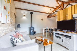 a living room with a large flat screen tv at le chai de la lumineuse in Saint-Pierre-dʼOléron