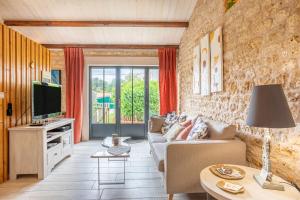 a living room with a couch and a tv at le chai de la lumineuse in Saint-Pierre-dʼOléron