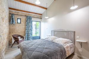 a bedroom with a large bed and a window at le chai de la lumineuse in Saint-Pierre-dʼOléron