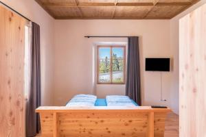 a bedroom with a bed and a window at Hof im Thal Apt Zirbe in Aldino