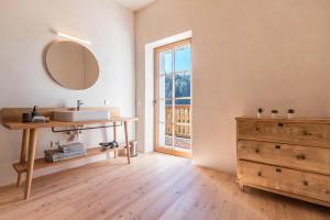 a bathroom with a sink and a mirror and a dresser at Hof im Thal Apt Zirbe in Aldino