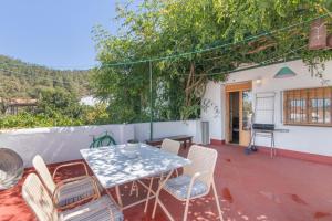a patio with a table and chairs on a deck at La Rana Verde de Arriba in Los Romeros