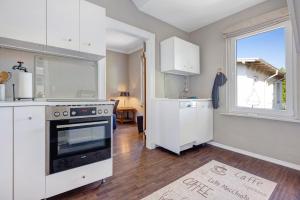 a kitchen with white cabinets and an oven and a window at Bei der alten Keksfabrik in Hamburg