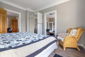 a bedroom with a bed and a wicker chair at Bei der alten Keksfabrik in Hamburg