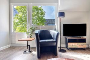 a living room with a chair and a television at Bei der alten Keksfabrik in Hamburg
