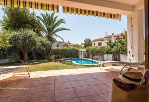 a patio with a view of a swimming pool at Villa 100 m from the beach in Roda de Bará