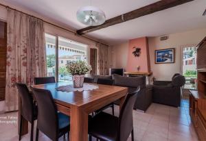 a dining room and living room with a wooden table and chairs at Villa 100 m from the beach in Roda de Bará