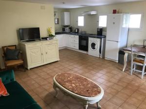 a kitchen with a white refrigerator and a table at Gite Le Lot in Bias