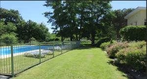 a fence next to a yard with a pool at Gite Le Lot in Bias