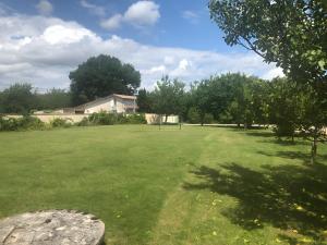 a large green field with trees and a building at Gite Le Lot in Bias