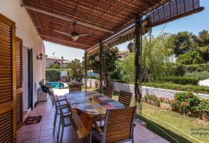 a patio with a table and chairs and a pool at Villa 100 m from the beach in Roda de Bará