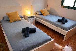 two beds in a room with black pillows on them at Kalendra Jable in Guatiza