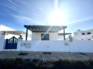 a white house with the sun shining behind it at Kalendra Jable in Guatiza