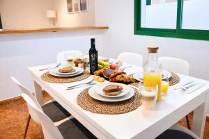 a table with plates of food and a bottle of wine at Kalendra Jable in Guatiza +25 photos