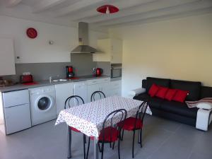 a kitchen and living room with a table and a couch at Charmant appartement à Ainhoa in Ainhoa