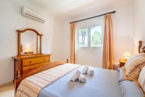 a bedroom with a bed with two towels on it at Lago y Playa in Port d'Alcudia