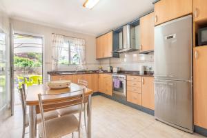 a kitchen with a table and a stainless steel refrigerator at Lago y Playa in Port d'Alcudia