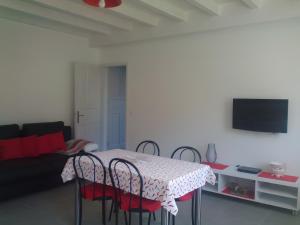 a room with a table with chairs and a couch at Charmant appartement à Ainhoa in Ainhoa