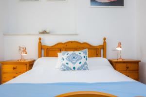 a bed with a blue and white pillow on it at Apartamento Can Jaume in Artá