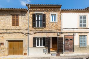 an old stone building with black shutters on it at Apartamento Can Jaume in Artá